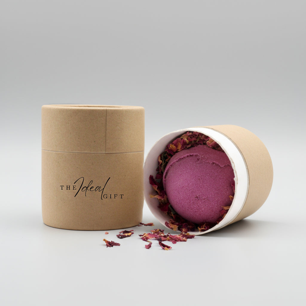 Purple bath bomb in a paper container with 'The Ideal Gift' branding on a white surface.