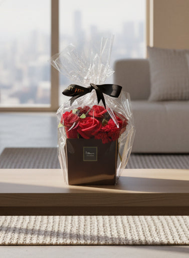 Bouquet of red roses in a clear cellophane wrap with a black ribbon on a gray background